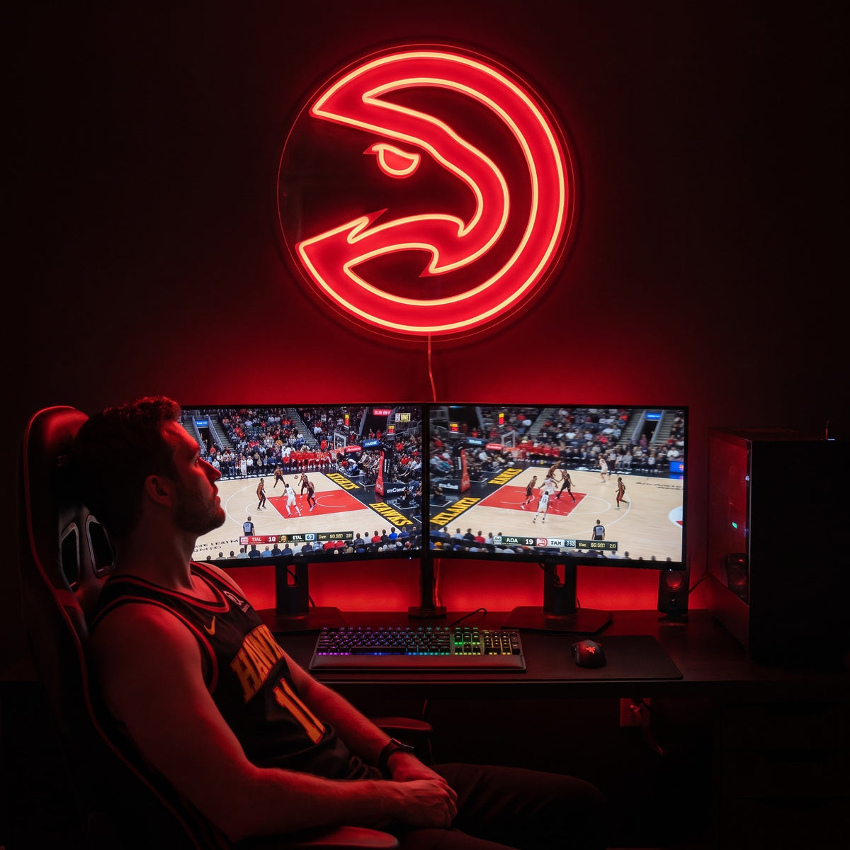 Atlanta Hawks LED neon sign glowing red above dual monitors showing basketball in a gaming room