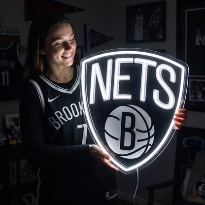 Woman holding a glowing Brooklyn Nets LED neon sign