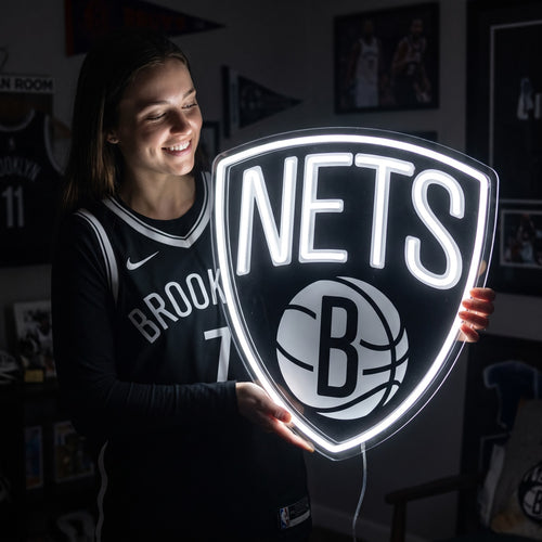 Woman holding a glowing Brooklyn Nets LED neon sign