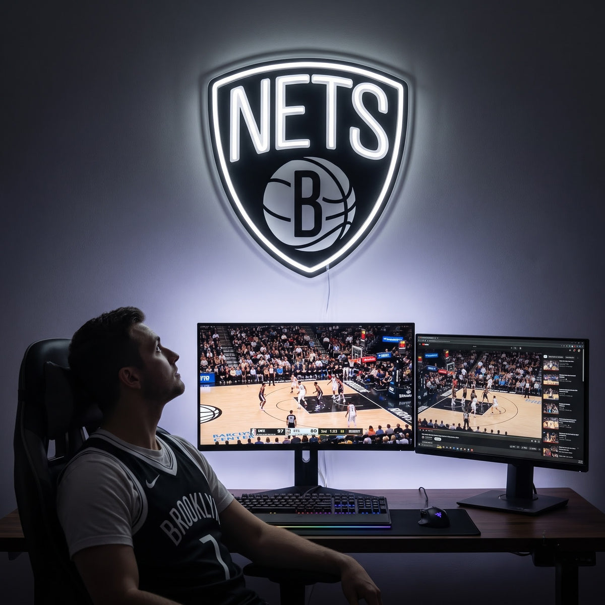 Brooklyn Nets LED neon sign above a gaming setup with a fan watching basketball