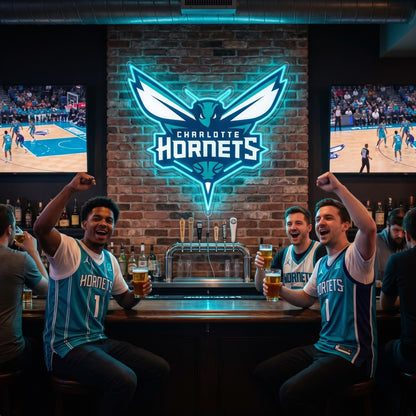 Charlotte Hornets LED neon sign on a brick wall above fans cheering at a sports bar with basketball on TV