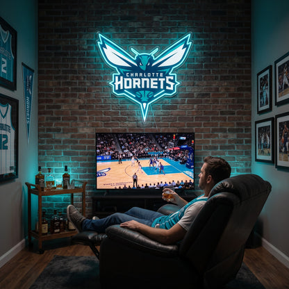 Charlotte Hornets LED neon sign above a TV in a man cave with framed jerseys, as a fan watches basketball from a recliner