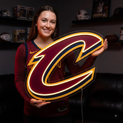 Cleveland Cavaliers LED neon sign - A smiling woman in a Cavaliers jersey holds a wine and gold Cleveland Cavaliers C logo neon sign.