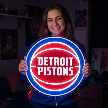 Woman holding a glowing Detroit Pistons LED neon sign