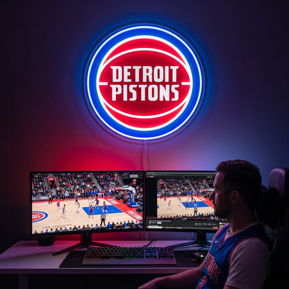 Detroit Pistons LED neon sign above a gaming setup with a fan watching basketball