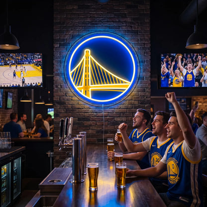 Golden State Warriors LED neon sign - Friends in Warriors jerseys cheer with beers at a sports bar under a Golden State Warriors bridge logo neon sign on a brick wall.