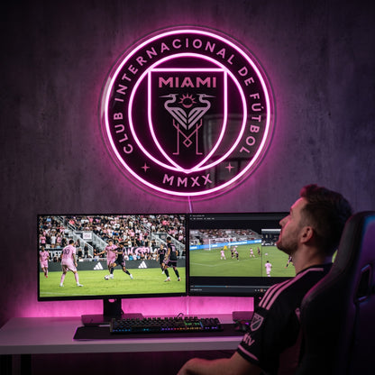 Inter Miami CF LED neon sign above a gaming setup with a fan watching soccer