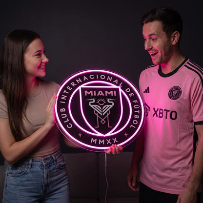 Woman surprising a soccer fan with a glowing Inter Miami CF LED neon sign gift