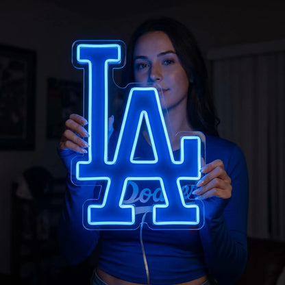 Los Angeles Dodgers LED neon sign - A woman holds a glowing blue Los Angeles Dodgers LA logo neon sign in a dark room.
