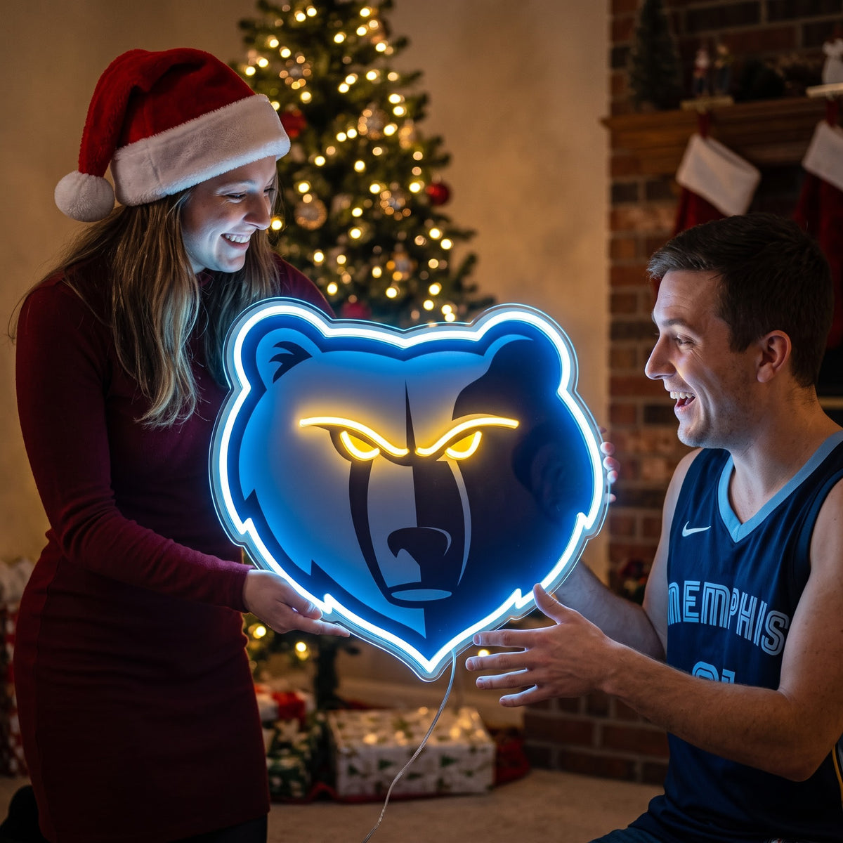 Couple exchanging a Memphis Grizzlies LED neon sign as a Christmas gift by the tree