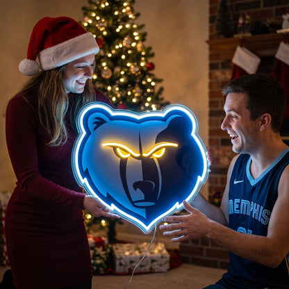 Couple exchanging a Memphis Grizzlies LED neon sign as a Christmas gift by the tree
