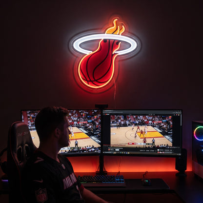 Miami Heat LED neon sign above dual monitors showing basketball in a game room with red ambient lighting