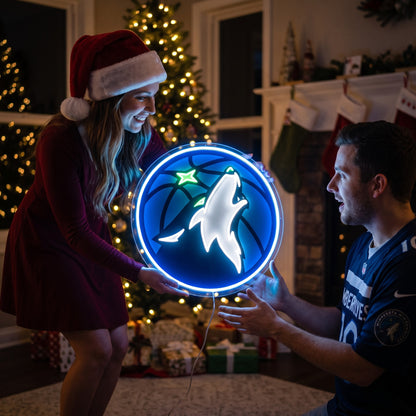 Couple exchanging a Minnesota Timberwolves LED neon sign as a Christmas gift by the tree