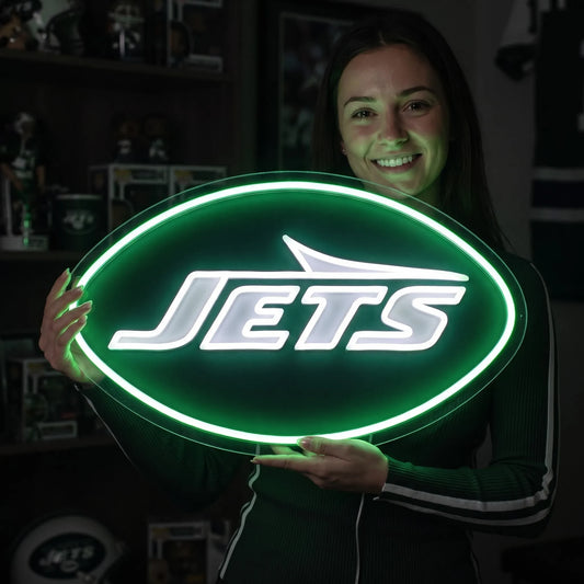 New York Jets LED neon sign - A woman holding a glowing oval New York Jets neon-style sign with the team name in white against a bright green background.