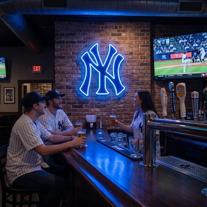 New York Yankees LED neon sign - Fans in Yankees jerseys enjoy beers at a sports bar under a blue NY Yankees logo neon sign on a brick wall.