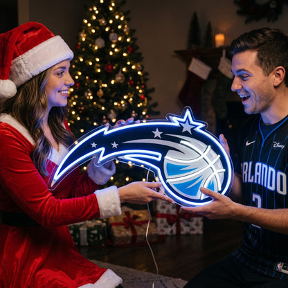 Couple exchanging an Orlando Magic LED neon sign as a Christmas gift by the tree