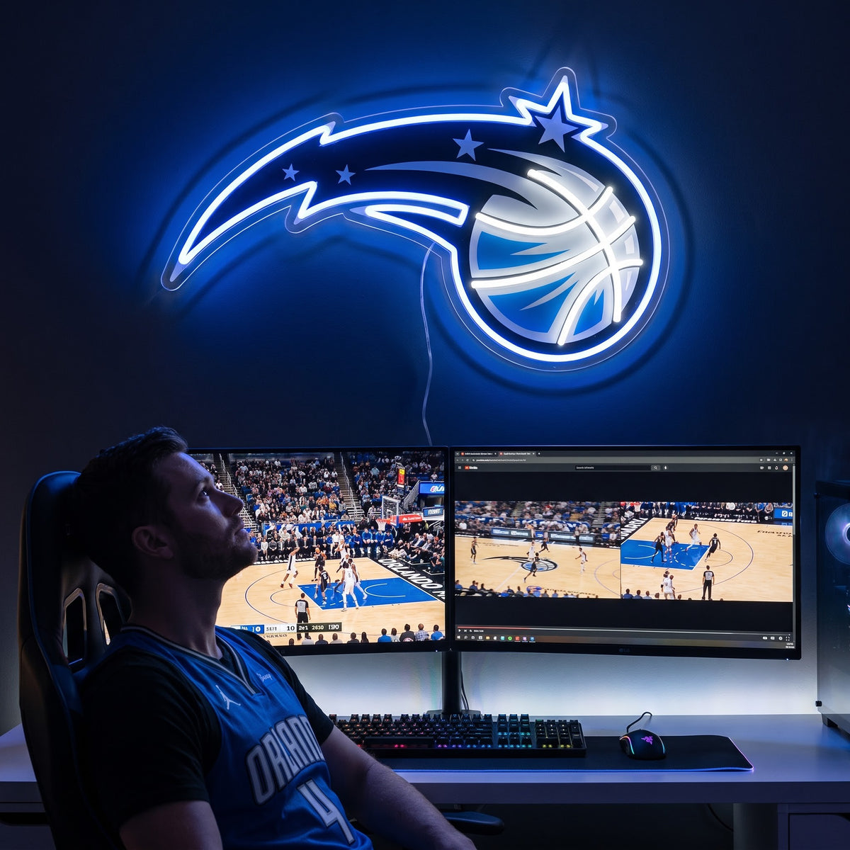 Orlando Magic LED neon sign above a gaming setup with a fan watching basketball