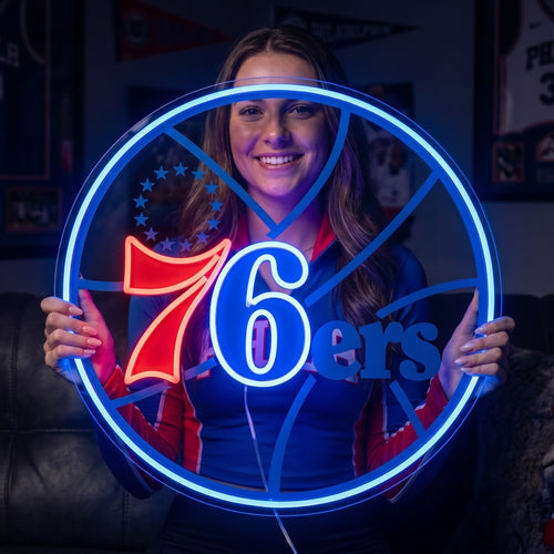 Woman holding a circular Philadelphia 76ers LED neon sign with a bright blue border and red and white logo details