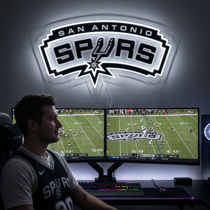 San Antonio Spurs LED neon sign above a gaming setup with a fan watching basketball