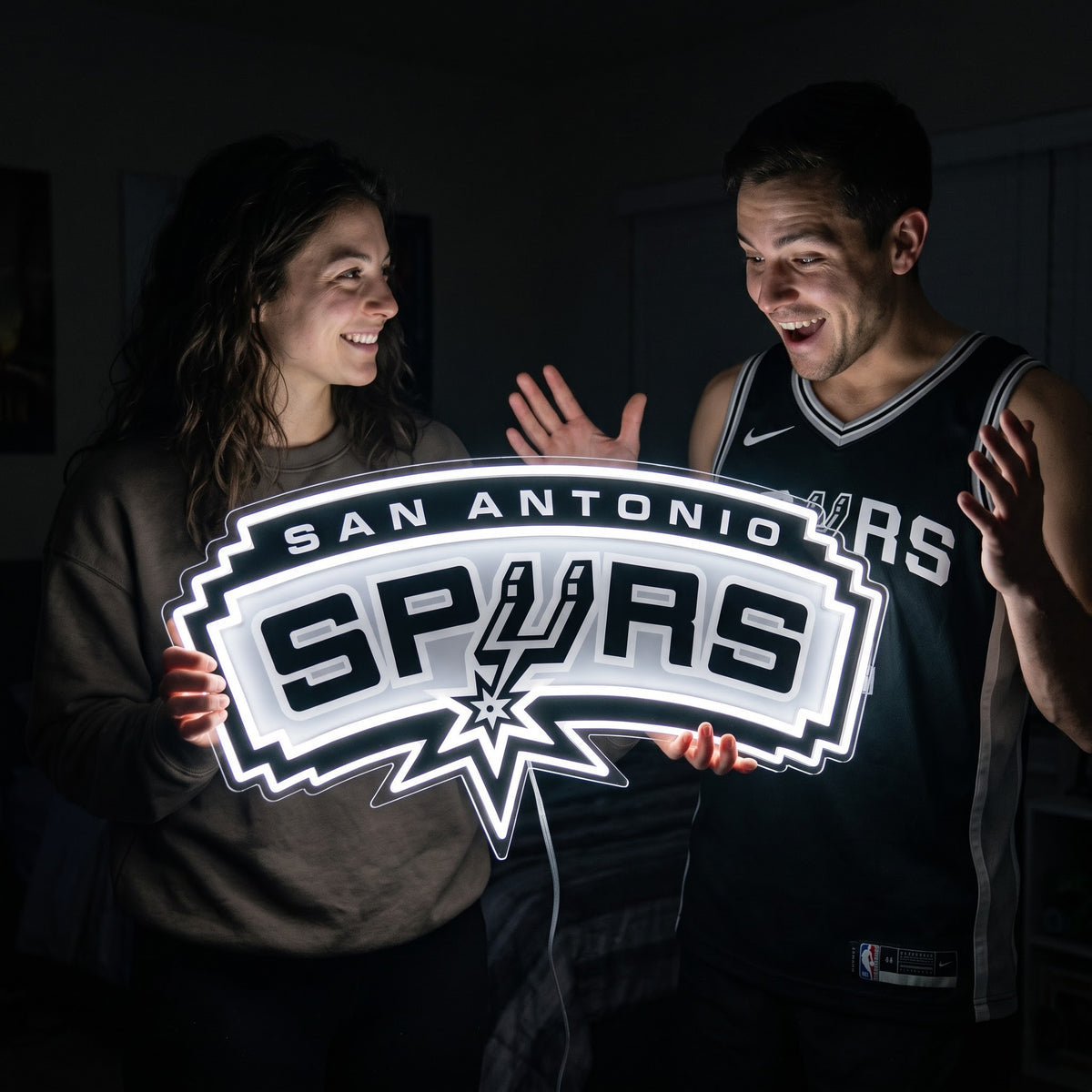 Woman surprising a basketball fan with a glowing San Antonio Spurs LED neon sign gift
