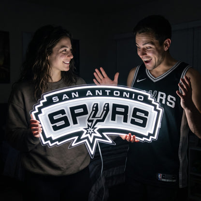 Woman surprising a basketball fan with a glowing San Antonio Spurs LED neon sign gift
