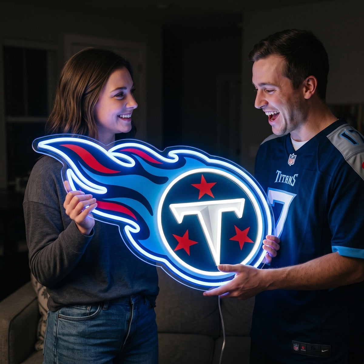Woman presenting a Tennessee Titans flame logo LED neon sign to a fan in a Titans jersey.