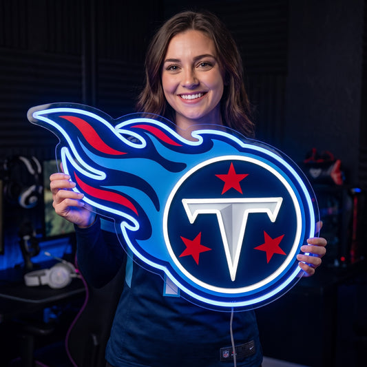 Woman holding an illuminated Tennessee Titans flame logo LED neon sign in a game room.