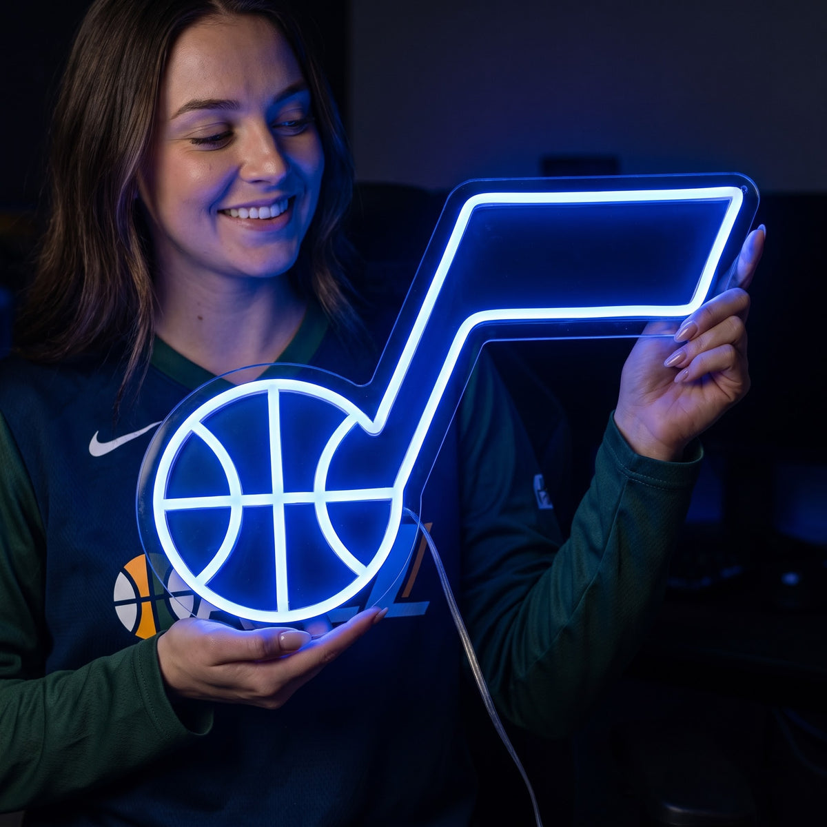 Woman holding a glowing Utah Jazz LED neon sign