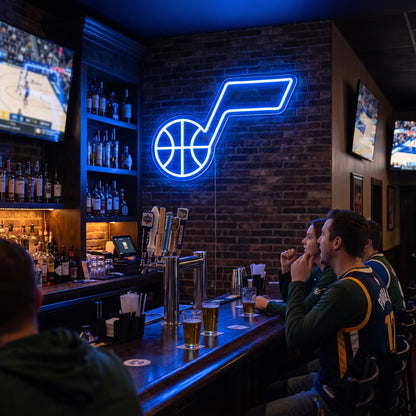 Utah Jazz LED neon sign on a brick wall in a sports bar with fans watching the game